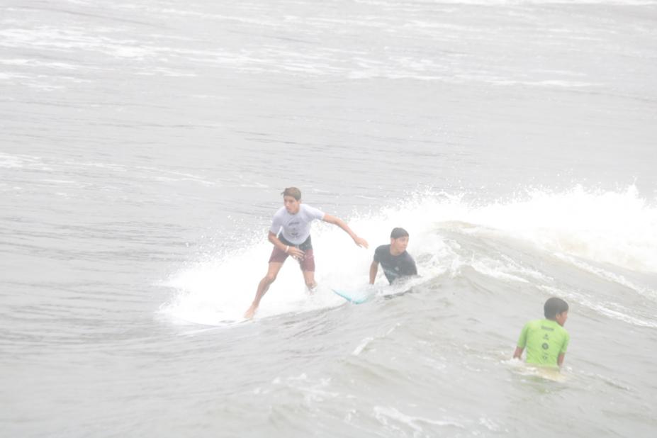 três jovens surfando. #paratodosverem