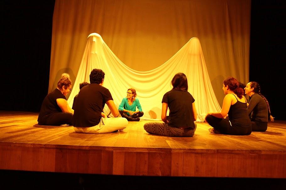 alunos de teatro estão sentado no palco conversando. #paratodosverem 