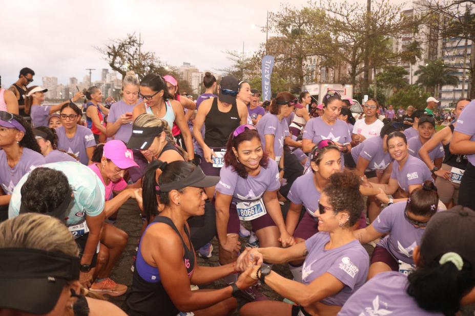mulheres uniformizadas fazem aquecimento para corrida. #paratodosverem