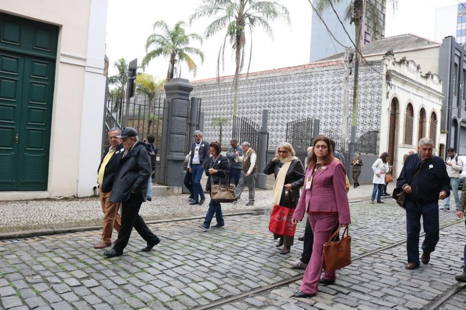 visitantes andam sobre calçamento de rua em frente ao outeiro de santa catarina. #paratodosverem