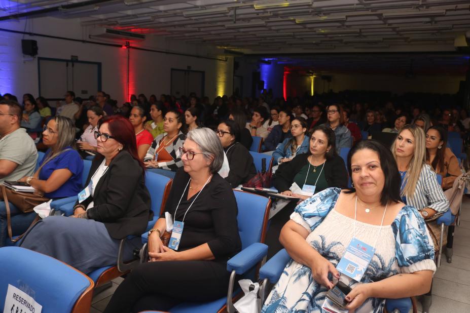 pessoas sentadas no auditório lotado #paratodosverem