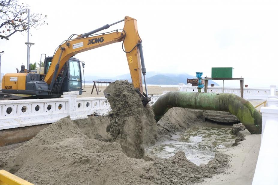 braço de escavadeira está lotado de areia removida de fundo de canal. #paratodosverem