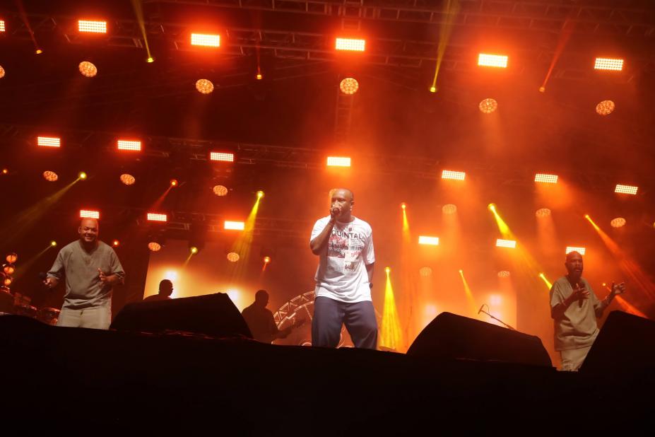 thiaguinho no palco e público em primeiro plano. É noite. #paratodosverem