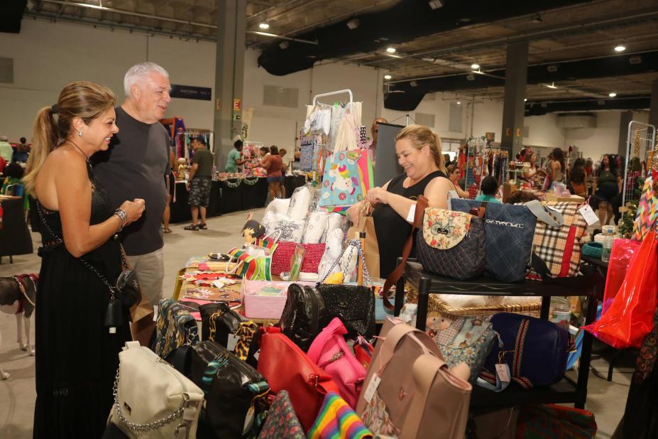 feira de artesanato com clientes e vendedora. #paratodosverem