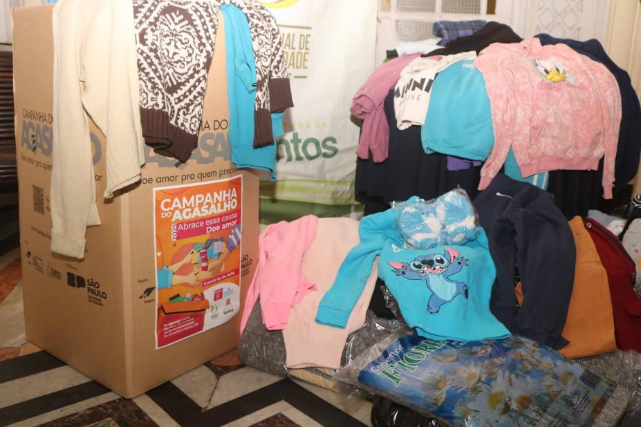 agasalhos diante de caixa de campanha. #paratodosverem