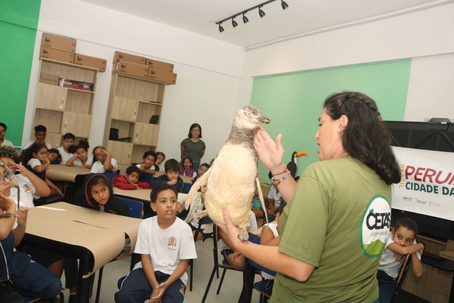 mulher mostra animal empalhado a crianças. #paratodosverem