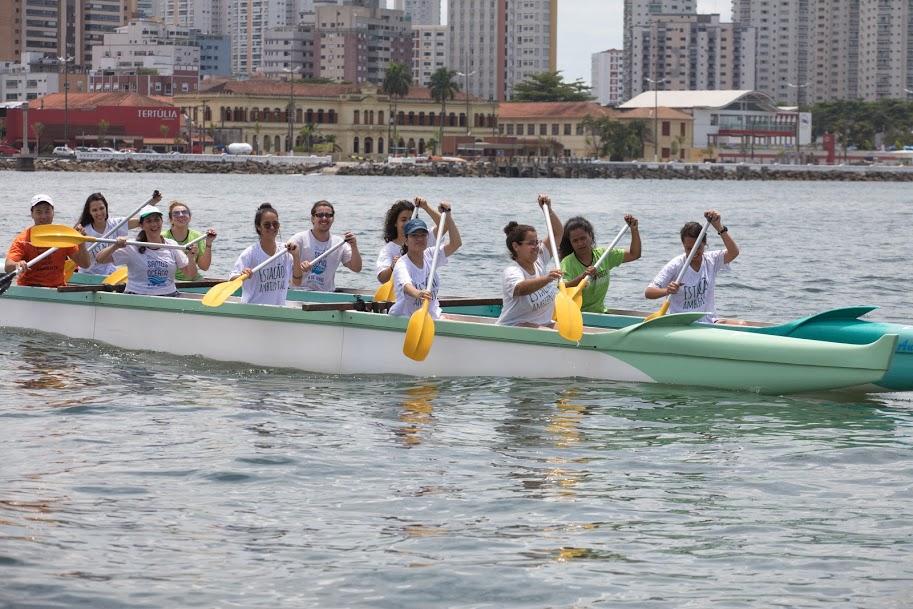 Voluntário remam em canoa havaiana. #pracegover