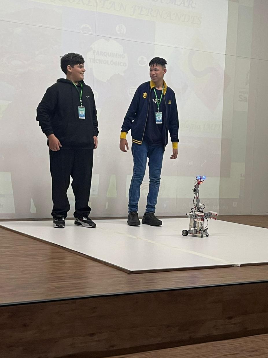 alunos com robô no palco #paratodosverem 