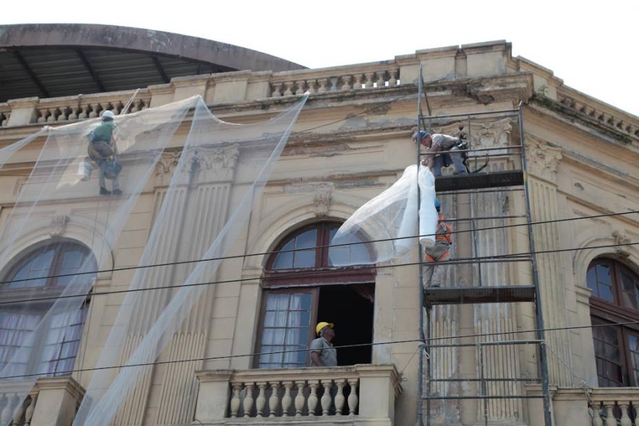 pessoas trabalhando em andaimes na fachada do teatro #paratodosverem