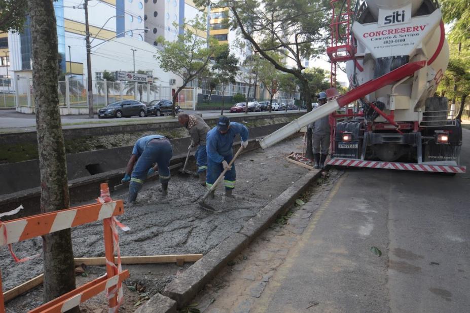 trabalhadores fazem concretagem em passeio ao lado de canal #paratodosverem