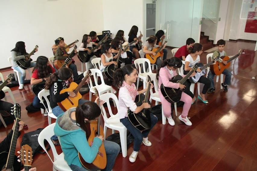 crianças tocam violão em aula #paratodosverem