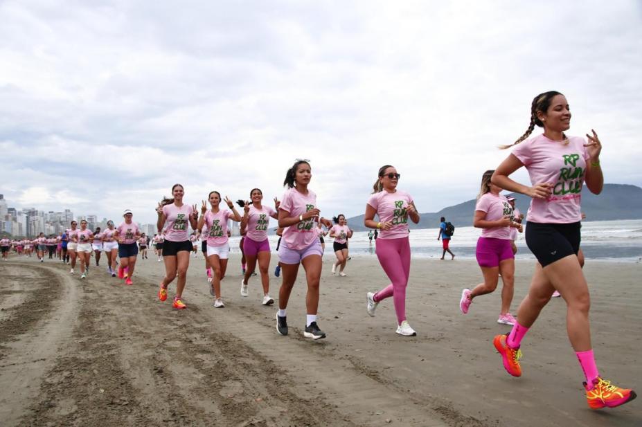 Mulheres correndo nas areias da praia de Santos. #Paratodosverem