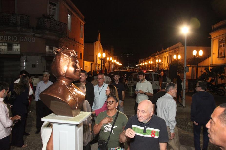 pessoas na praça ao lado do busto #paratodosverem