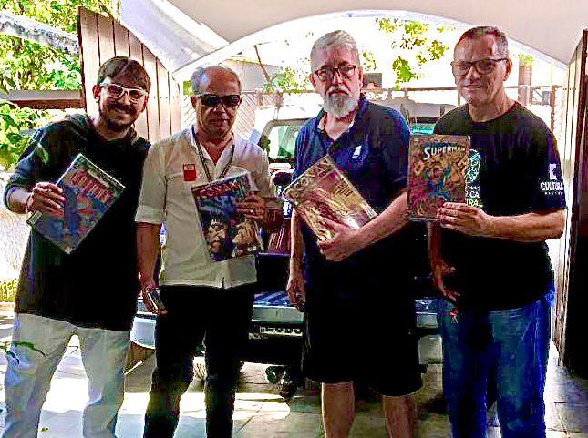 quatro homens posam para foto segurando gibis. #paratodosverem