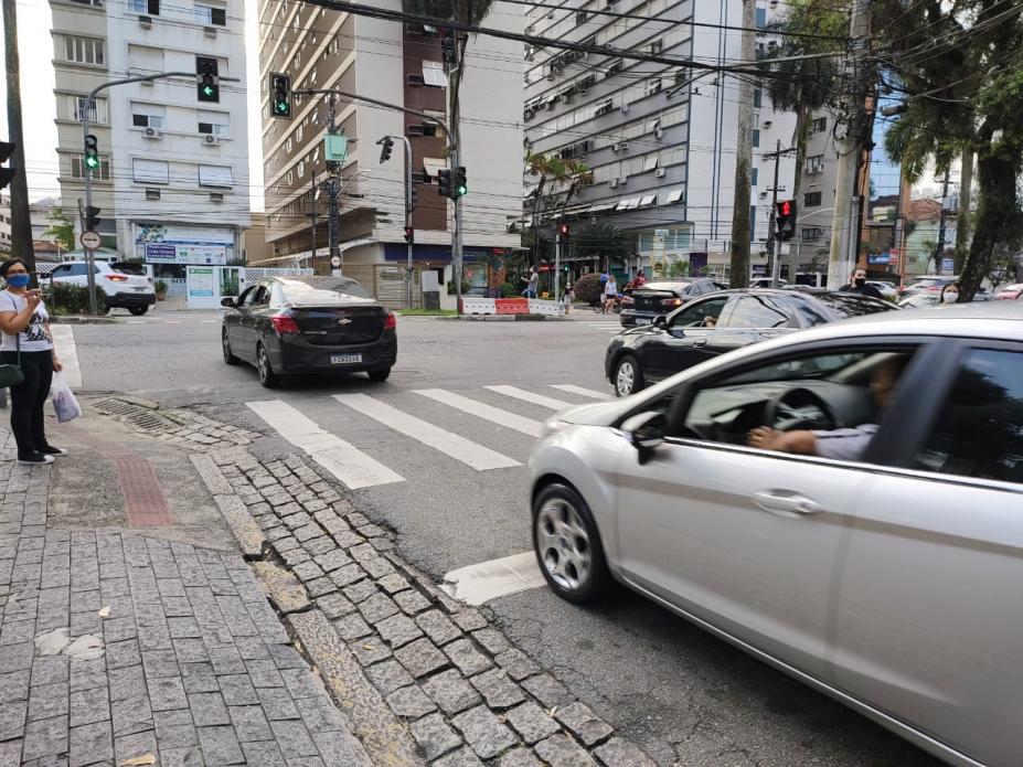 rua com carros passando e semáforo à frente. #paratodosverem