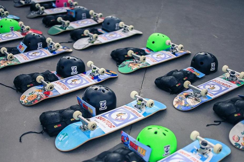 skates e capacetes dispostos no chão. #paratodosverem