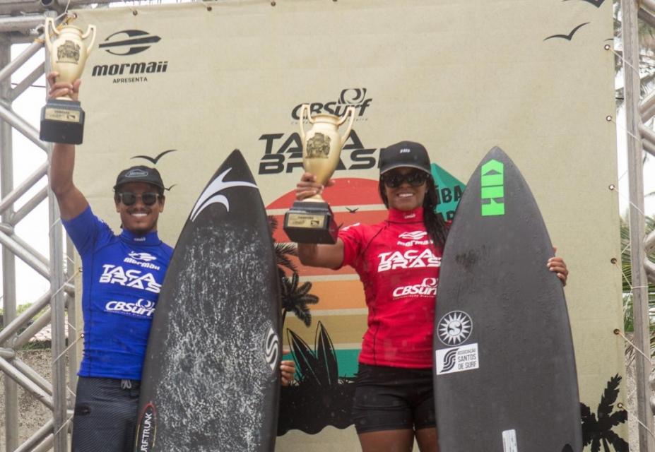 mar e julia estão lado ao lado segurando troféus. #paratodosverem