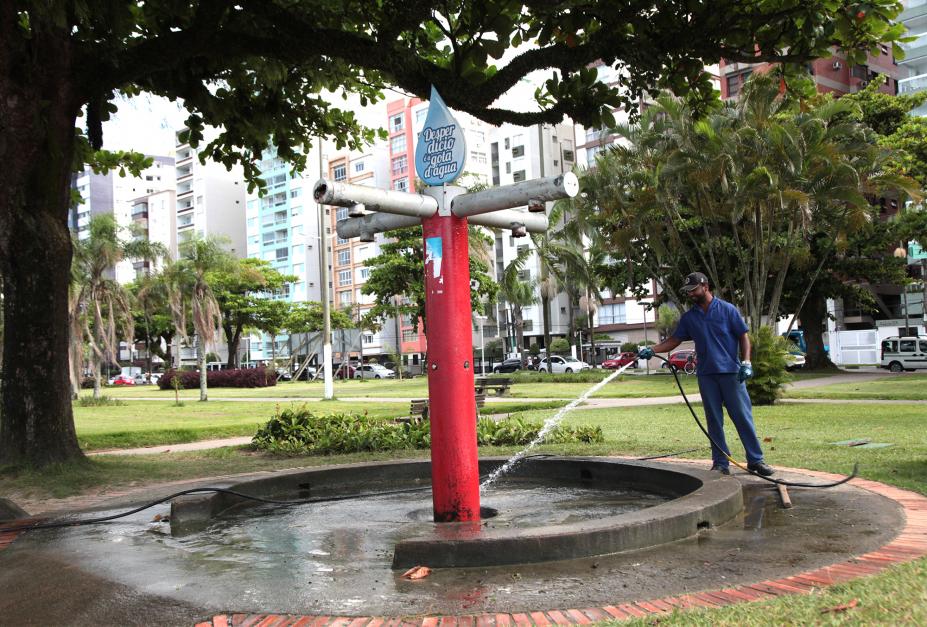 operário limpa piso de chuveiro com mangueira #pracegover 