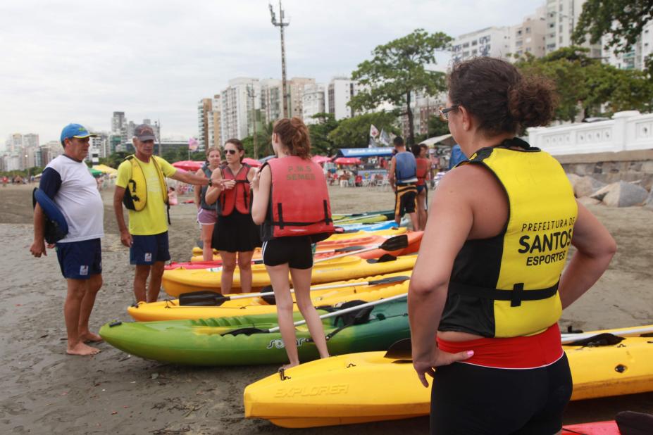 alunos na areia se preparando para aula de canoagem #pracegover 