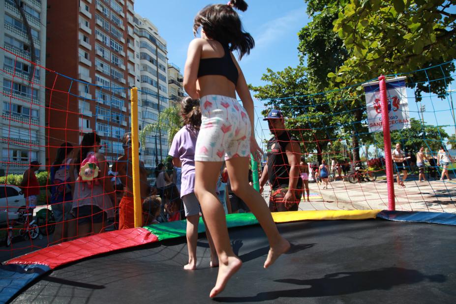 Crianças brincam em pula-pula armado na avenida da praia. #Pracegover