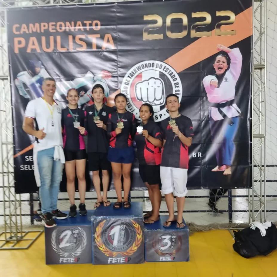 Pódio com equipe de Santos e o técnico. São cinco atletas. #paratodosverem