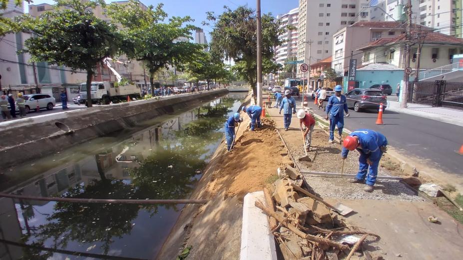 homens estão fazendo obras em talude de canal. #paratodosverem 