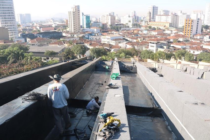 Operários realizam impermeabilização de cobertura. #pracegover