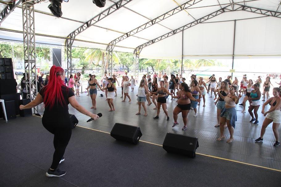 Mulheres dançam em tenda montada na praia. #pratodosverem