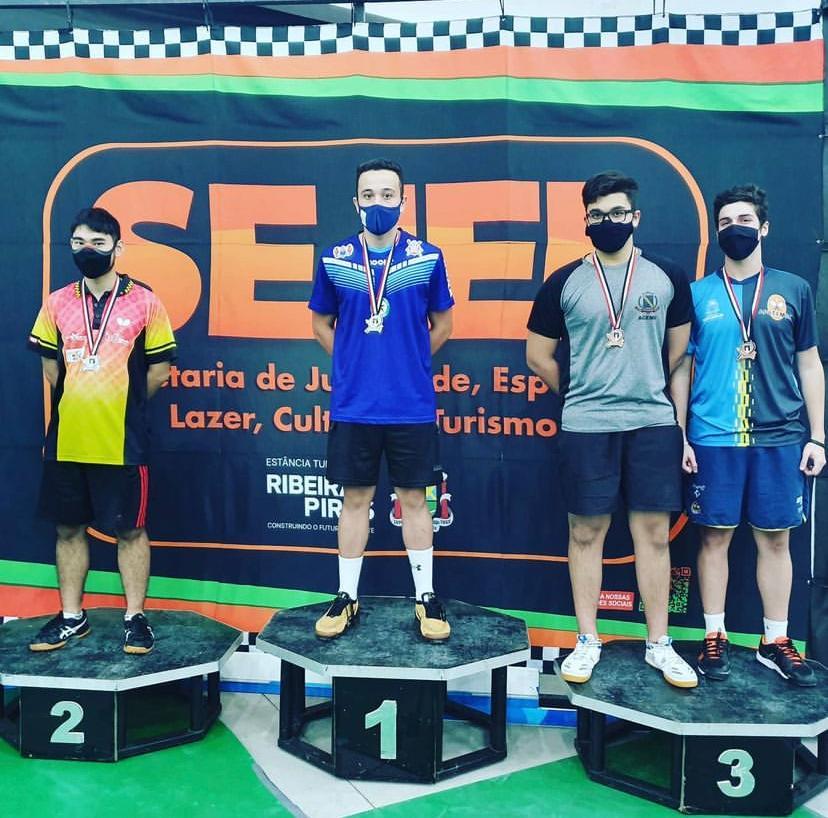 Richard Pinheiro no número um do pódio. Há um rapaz em segundo lugar e dois em terceiro. #paratodosverem