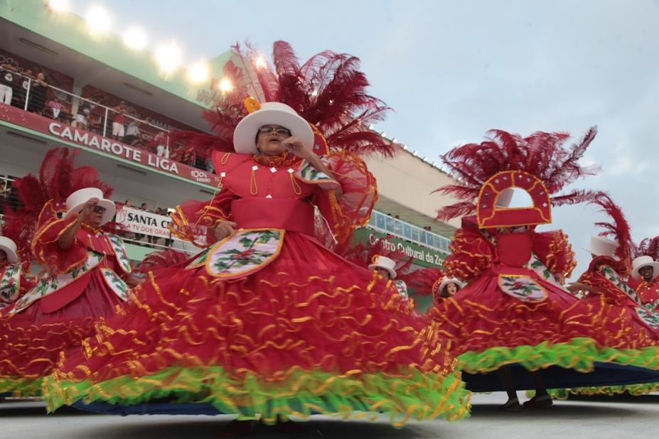 Mulher desfila na ala das baianas no carnaval #paratodosverem