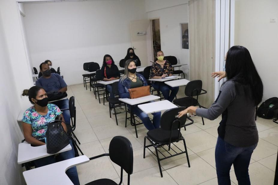 Profissional ministra curso para participantes na sala de aula #paratodosverem