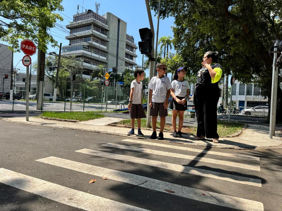 crianças fazem travessia de faixa de segurança sob monitoramento de uma mulher. #paratdosoverem