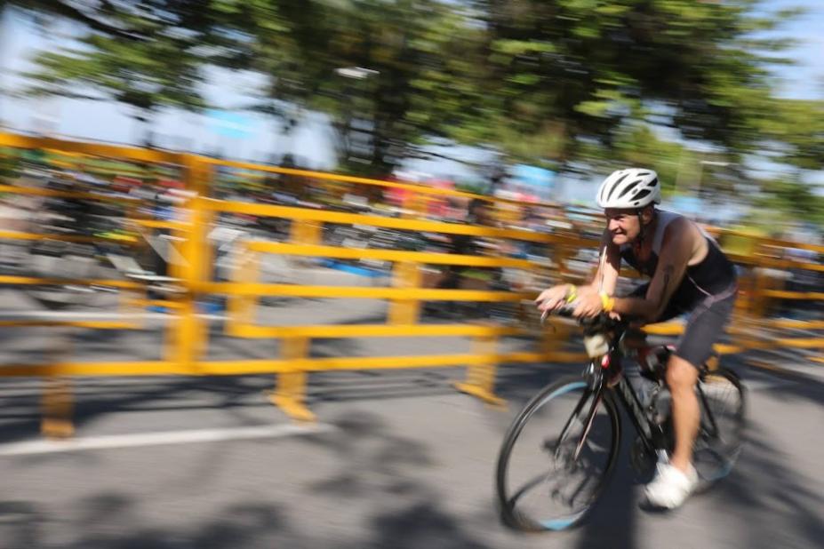 ciclista percorre avenida. A imagem mostra a velocidade com que ele passa porque o fundo está desfocado. #paratodosverem