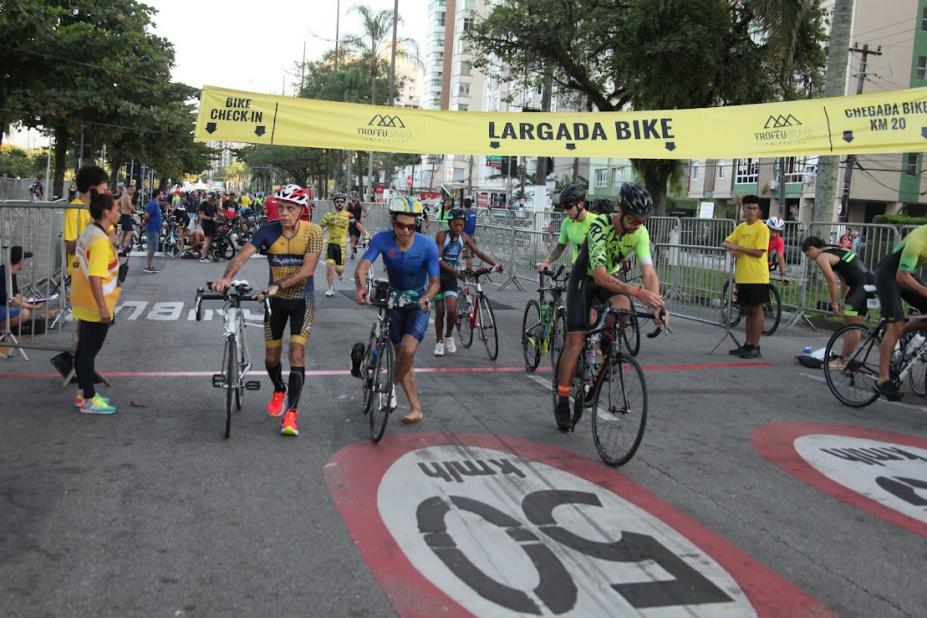 atletas pegando bicicleta durante a prova #paratodosverem 