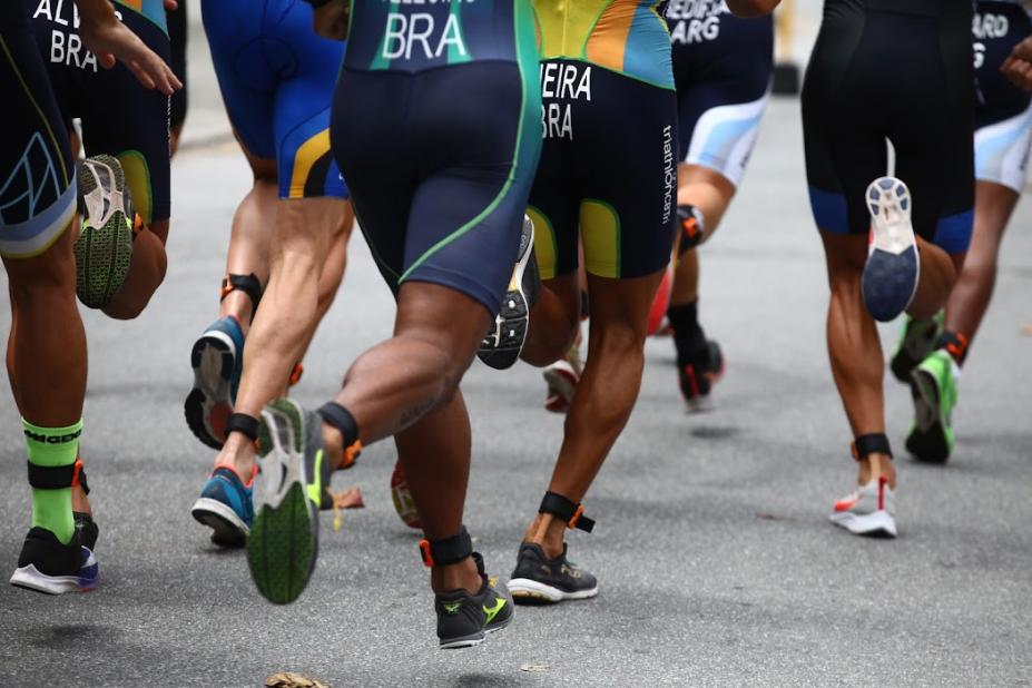 Imagem mostra homens correndo de costas, da altura da cintura para baixo. #pratodosverem