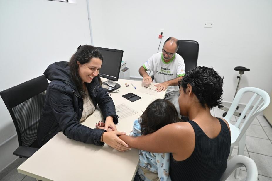 mulher sendo atendida com criança no colo #paratodosverem