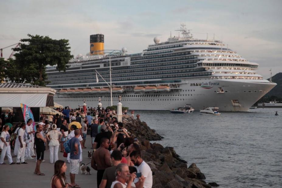 navio sai pelo canal do porto, sendo avistado por público na ponta da praia. #paratodosverem 