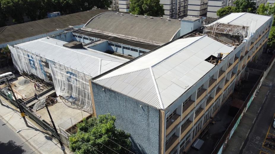 vista geral dos prédios com a fachada lateral coberta por manta. #paratodosverem