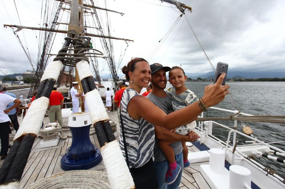 Casal e criança tiram selfie dentro de navio veleiro. #paratodosverem