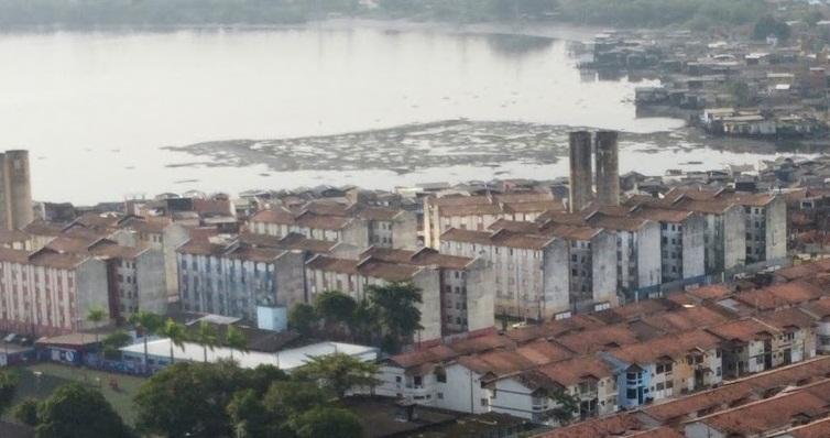 vista aérea de parte do conjunta habitacional com o mar ao fundo. #paratodosverem
