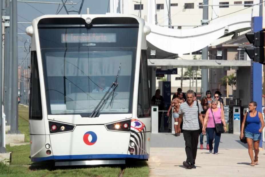 carro do vlt parado em estação. Passageiros na estação ao lado direito. #paratodosverem