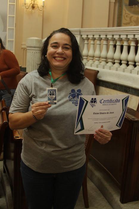 Voluntária exibe crachá e certificado recebidos na Sala Princesa Isabel. #paratodosverem