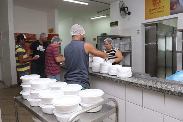 pESSOAS DENTRO DE RESTAURANTE, USANDO TOUCAS E LUVAS PREPARAM MARMITAS DE REFEIÇÕES. #Paratodosverem