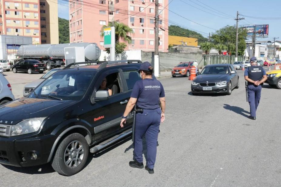 Agentes da guarda municipal estão abordando veículos na pista. #Paratodosverem