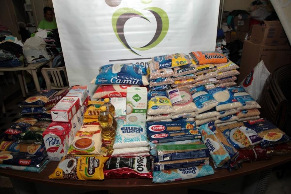 #pracegover Foto mostra dezenas de pacotes de alimentos sobre mesa