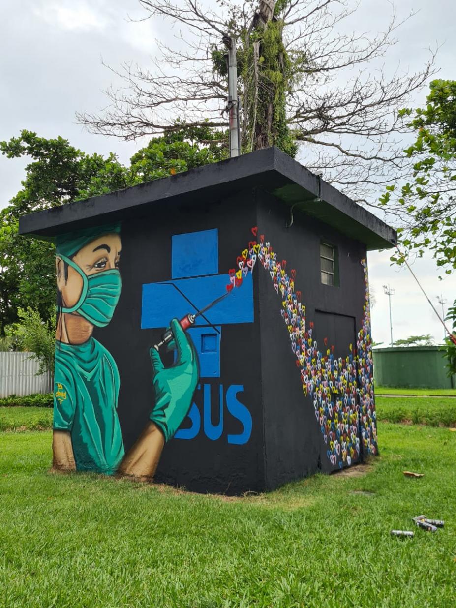 #paratodosverem estrutura em forma de cubo no jardim da praia tem pintura de enfermeira com seringa disparando corações