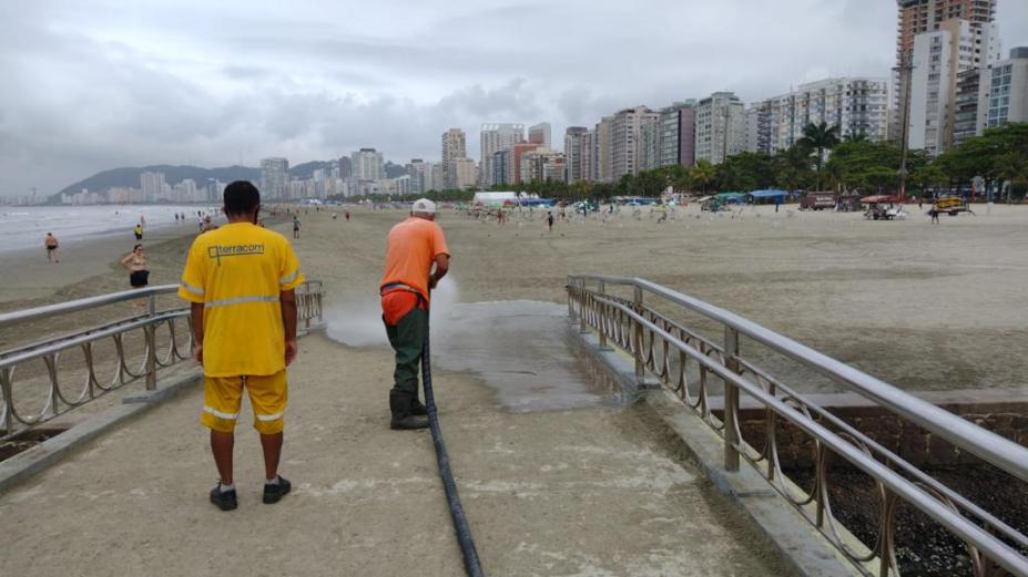 homens limpando pontilhão na praia #paratodosverem