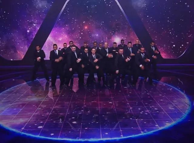 dançarinos de terno no palco #paratodosverem