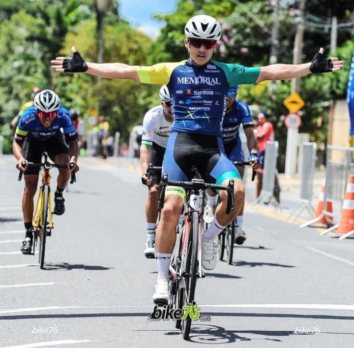 ciclista estende os braços comemorando vitória #paratodosverem