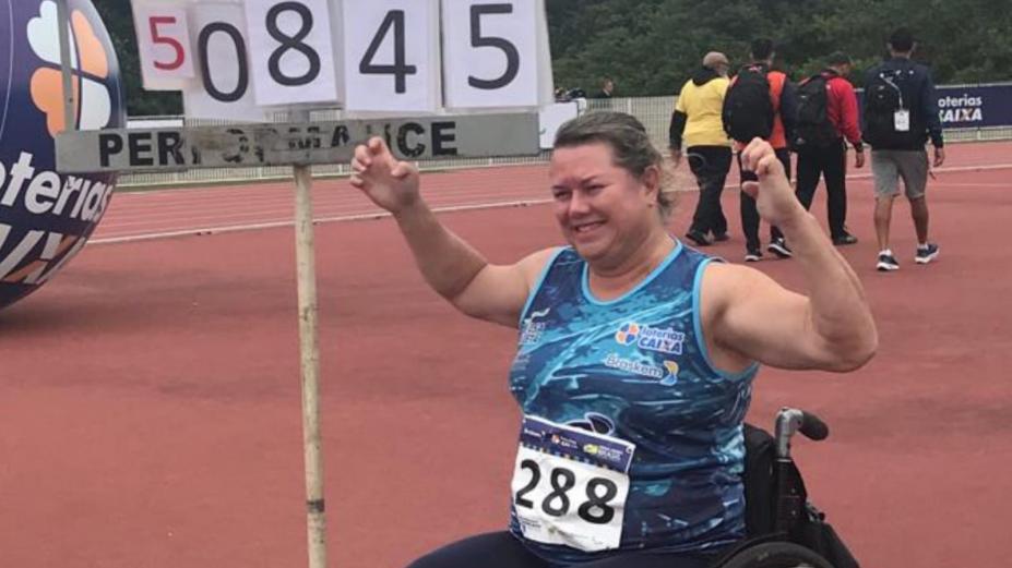 atleta ergue braço comemorando a vitória sentada na cadeira de rodas #paratodosverem